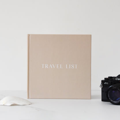 Beige travel list book with a camera on a white background
